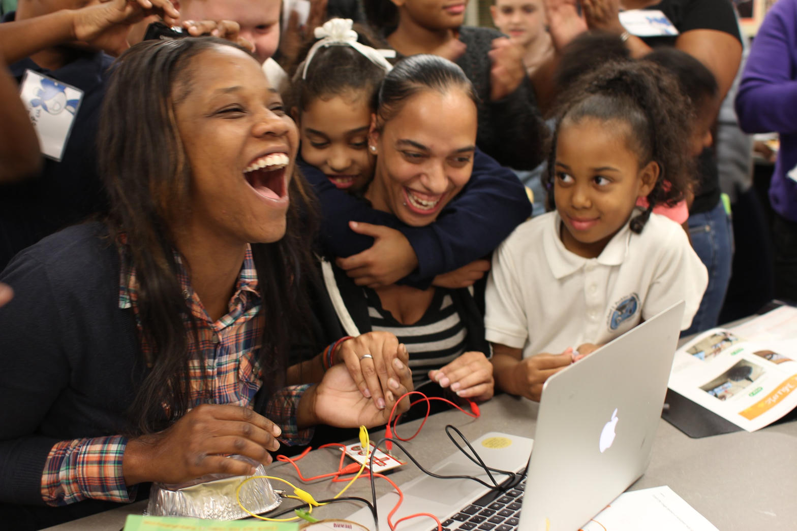 Family learning together at a laptop workshop